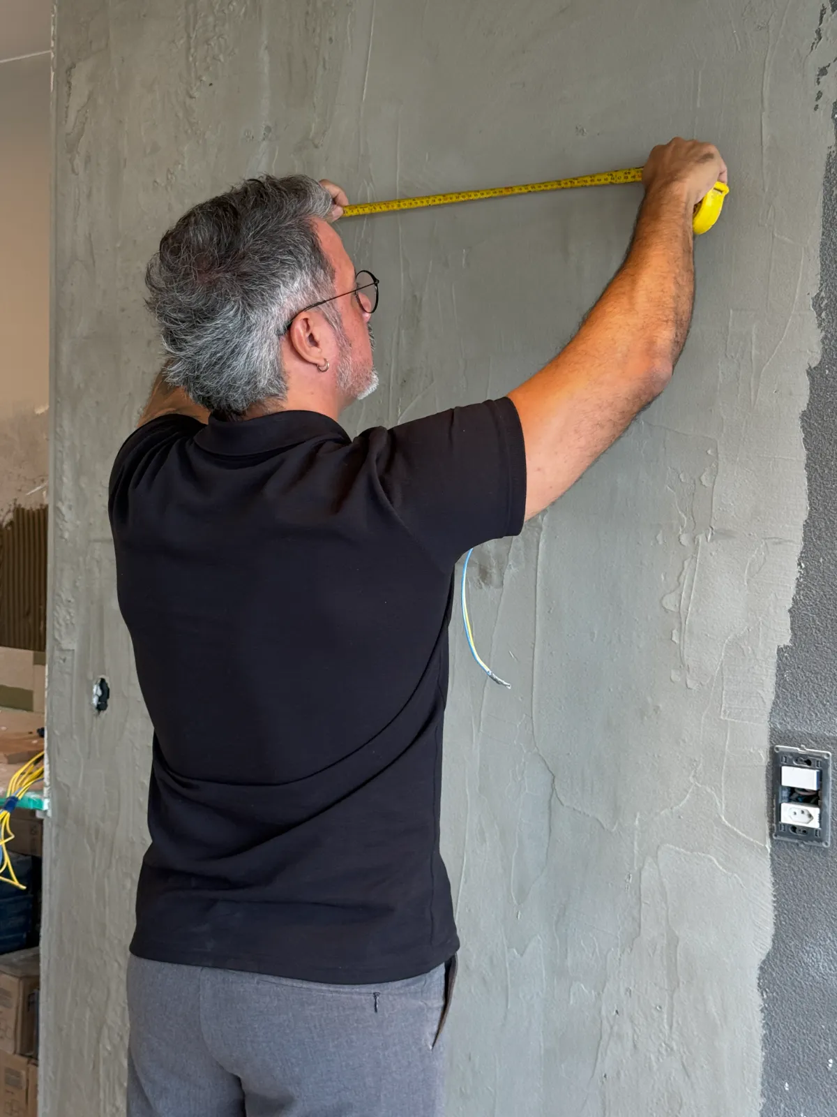 Eu medindo a parede durante a visita de obra