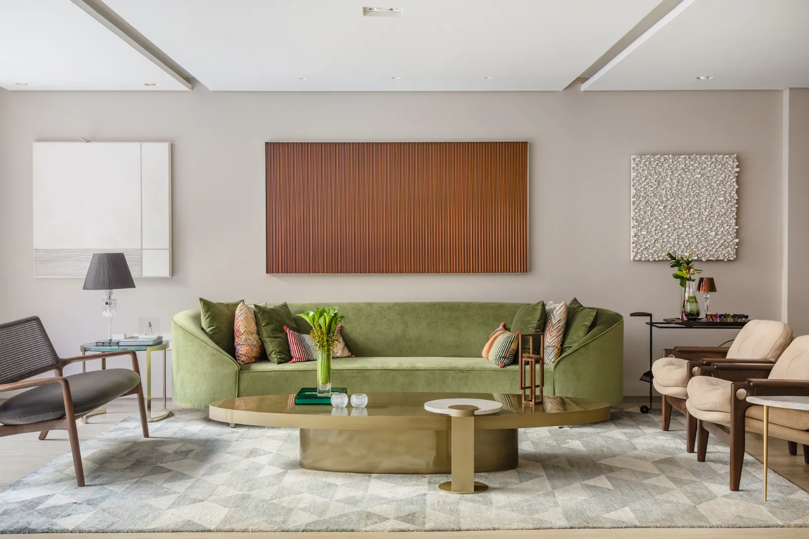 Sala íntima com sofá de veludo verde e arte, por Dan Barros
