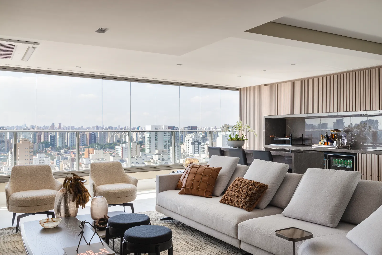 Living aberto para a vista de São Paulo com bar ao lado, por Dan Barros