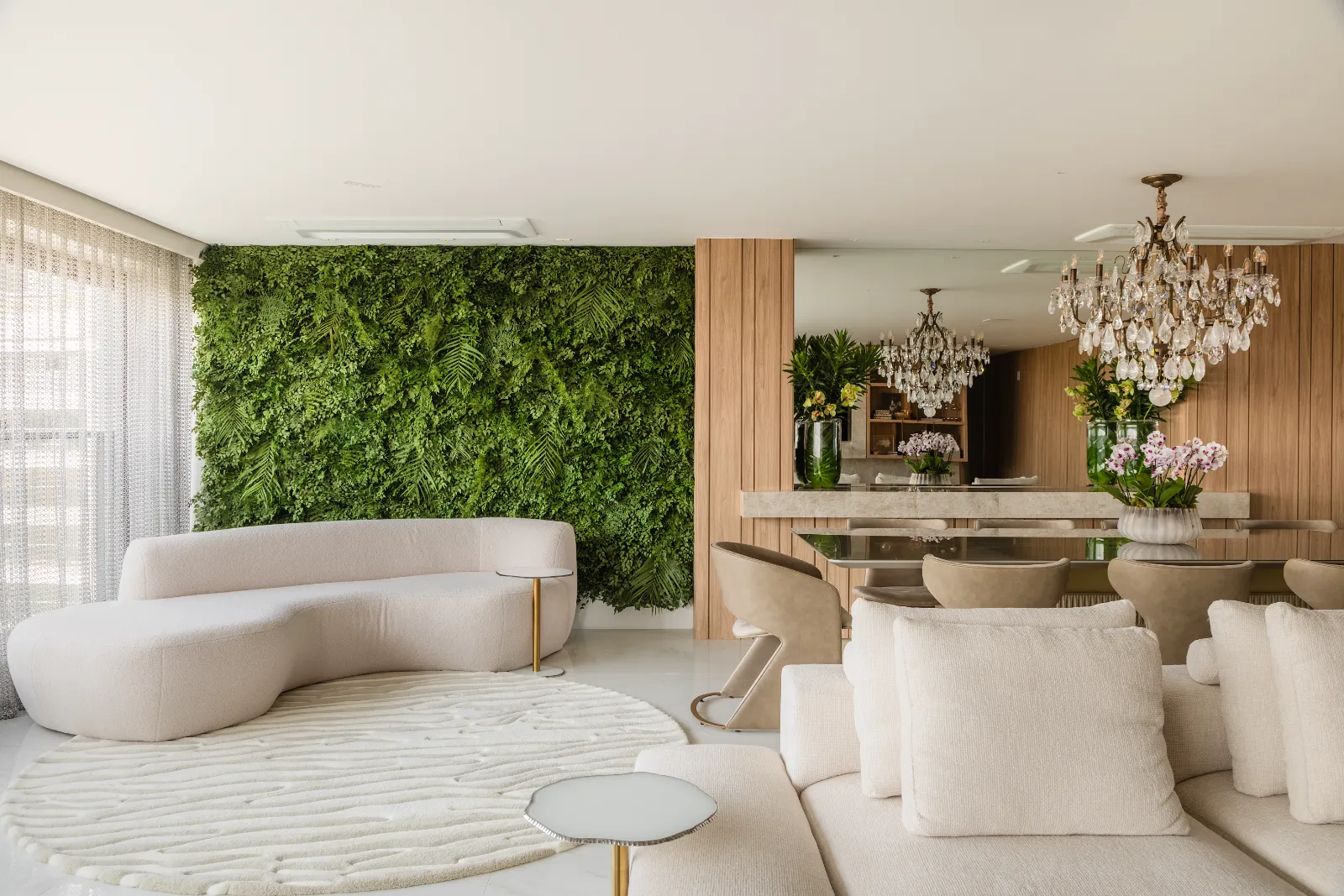 Apartamento Pintassilgo, estar com sofá curvo e jardim vertical