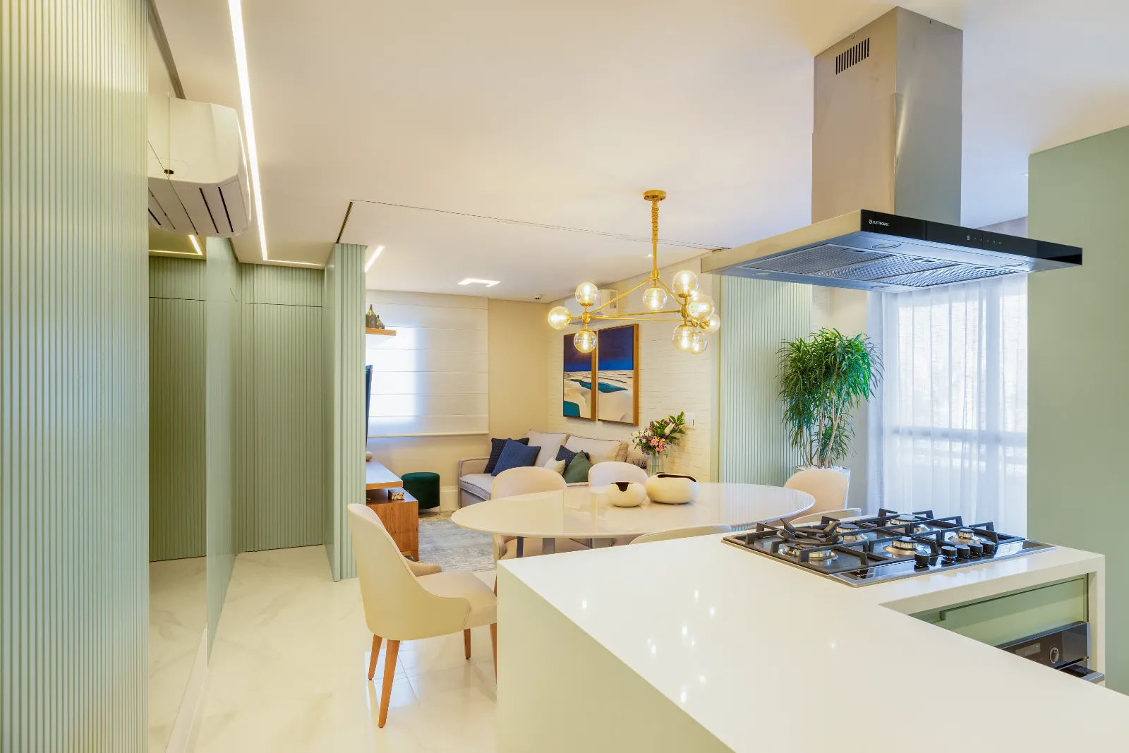 Ambientes integrados em verde sálvia vistos da cozinha, por Dan Barros